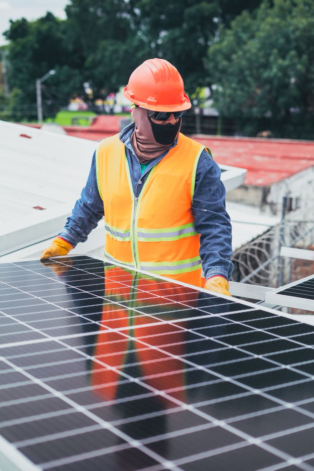 Installer positioning a photovoltaic module on a rooftop array